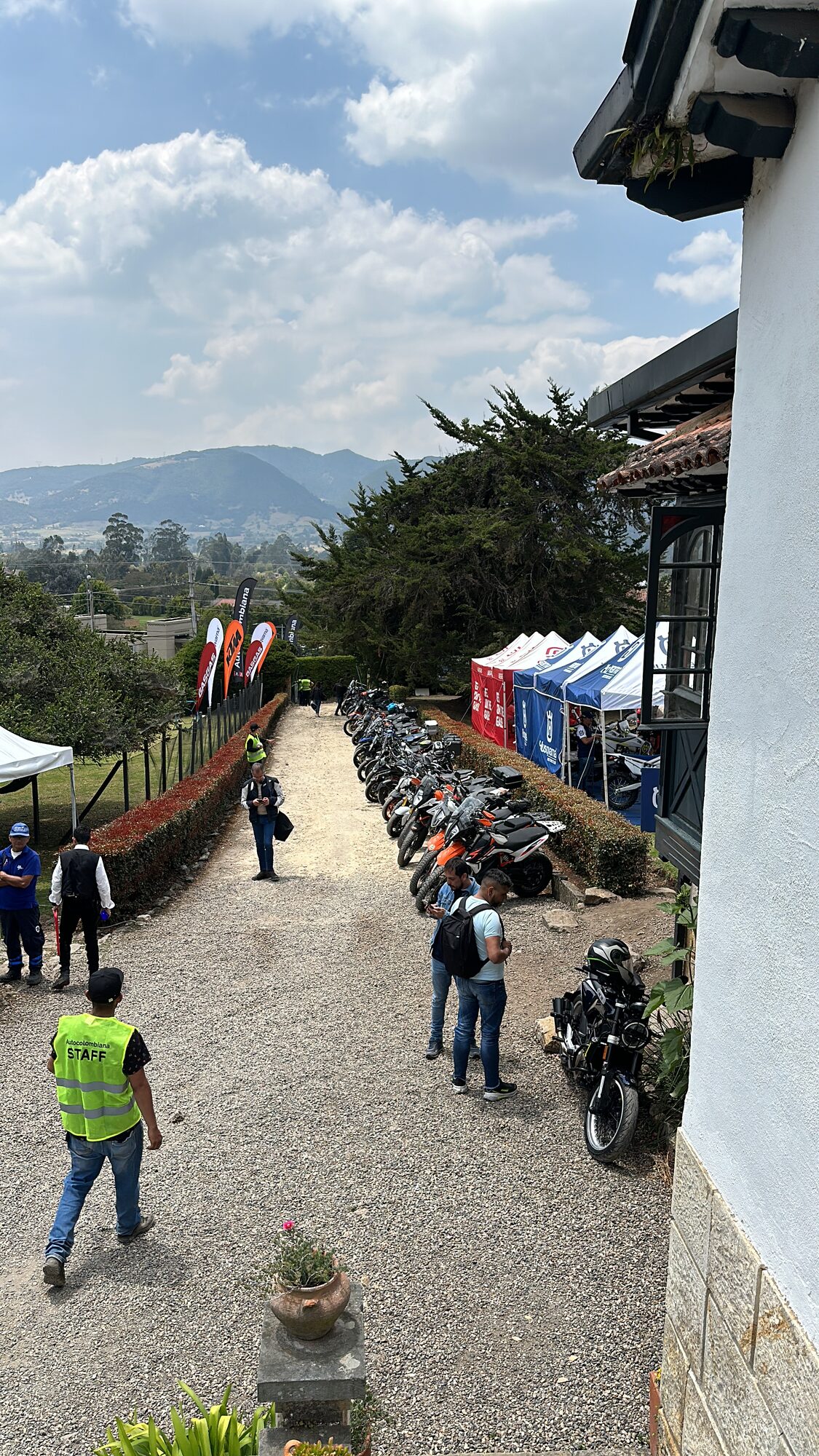 Fila de motos de exhibición junto al camino empedrado de La Quinta con las montañas de fondo