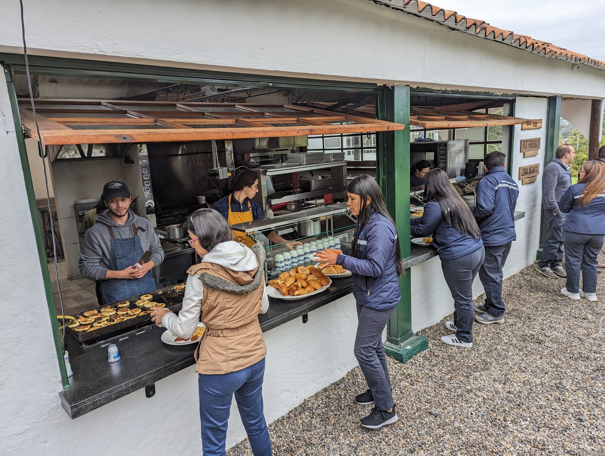 Barra caliente de autoservicio con staff sirviendo comida recién hecha